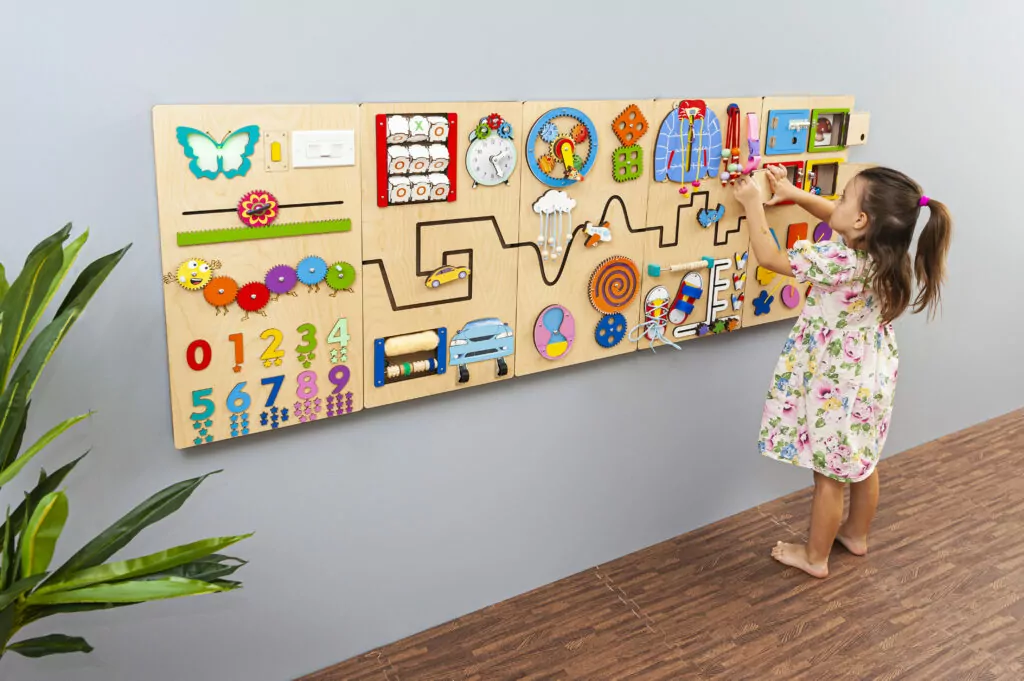 Children exploring BumblebeeSmart busy boards for toddlers and preschoolers, interactive activity panels for fine motor skills and sensory play.